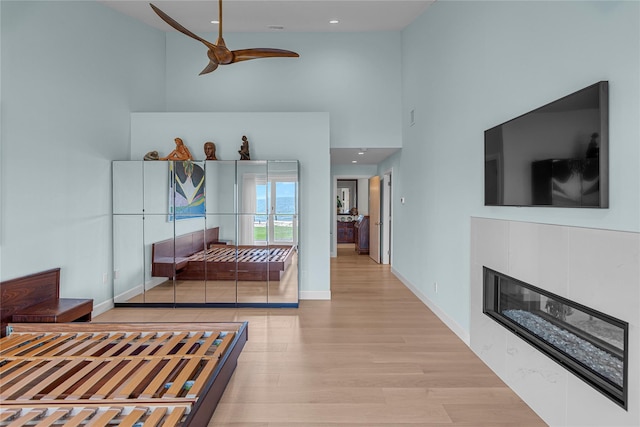 9 Captains Walk E, Bay Shore, NY 11706 - bedroom with a high ceiling, light wood finished floors, a glass covered fireplace, recessed lighting, and ceiling fan