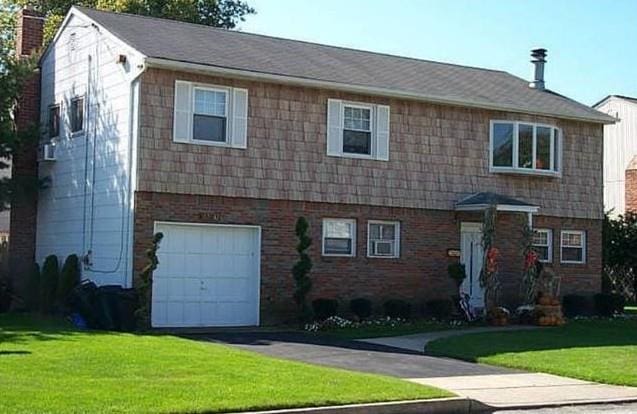 1040 Donna Ct, Baldwin, NY 11510 - view of front of house featuring an attached garage, a front yard, a chimney, and brick siding