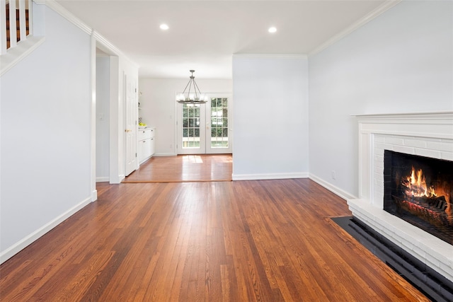 15 Le Britton St, Locust Valley, NY 11560 - unfurnished living room with a chandelier, wood finished floors, a brick fireplace, recessed lighting, and ornamental molding