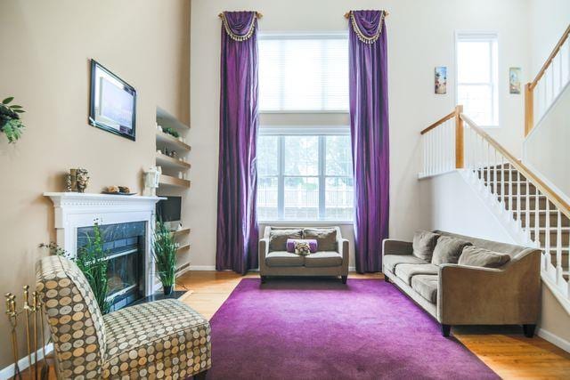 97 Reunion Rd, White Plains, NY 10603 - living room featuring healthy amount of natural light, wood finished floors, stairway, and a fireplace