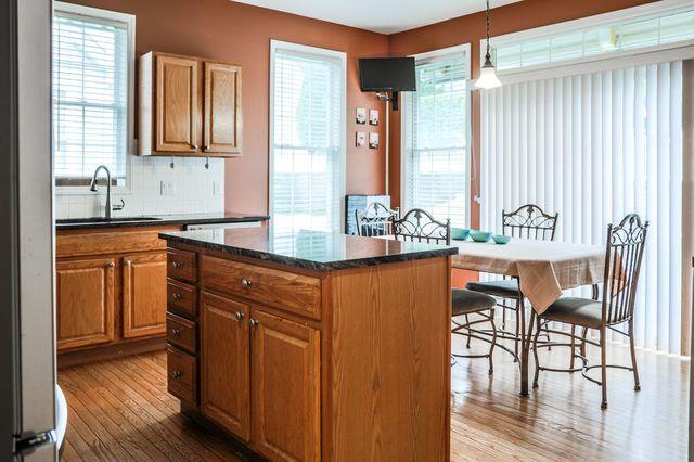 97 Reunion Rd, White Plains, NY 10603 - kitchen featuring light wood-type flooring, brown cabinets, and plenty of natural light