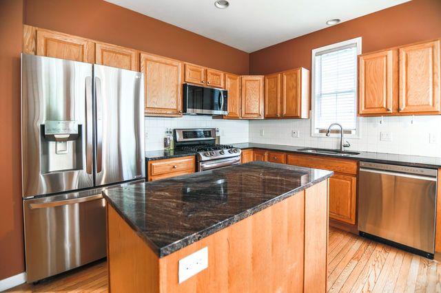 97 Reunion Rd, White Plains, NY 10603 - kitchen with appliances with stainless steel finishes, a center island, light wood-style floors, tasteful backsplash, and recessed lighting