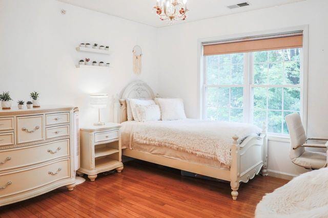 97 Reunion Rd, White Plains, NY 10603 - bedroom with multiple windows, dark wood finished floors, and a chandelier