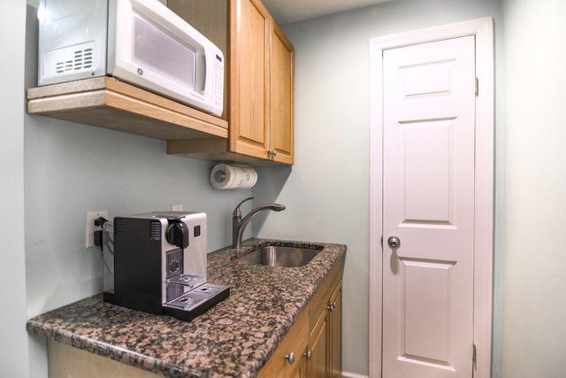 97 Reunion Rd, White Plains, NY 10603 - kitchen with white microwave and dark stone counters