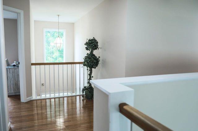 97 Reunion Rd, White Plains, NY 10603 - corridor with wood finished floors, a chandelier, and an upstairs landing