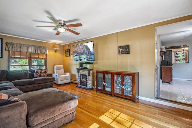 30 Lincoln Ave, Port Jefferson Station, NY 11776 - living area featuring a ceiling fan, wood finished floors, crown molding, a warm lit fireplace, and a baseboard radiator