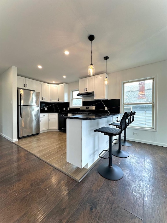 37 E Fulton St, Lido Beach, NY 11561 - kitchen with stainless steel appliances, a peninsula, dark countertops, wood finished floors, and recessed lighting
