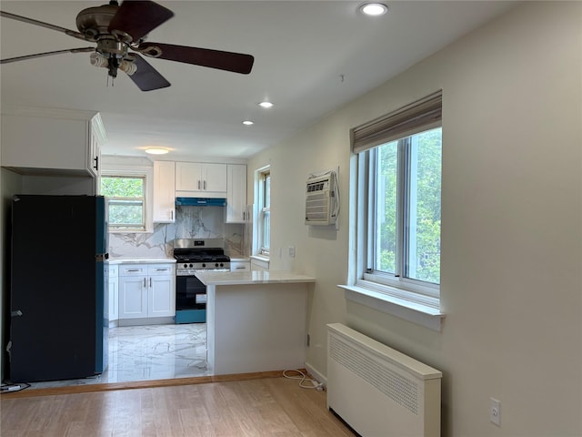 255-31 75th Ave Fl 2Nd, Glen Oaks, NY 11004 - kitchen with freestanding refrigerator, stainless steel gas stove, a wall mounted AC, white cabinetry, and recessed lighting