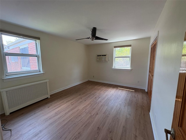 255-31 75th Ave Fl 2Nd, Glen Oaks, NY 11004 - empty room featuring radiator, a wall unit AC, wood finished floors, and a ceiling fan