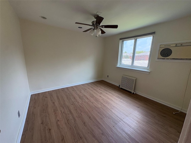 255-31 75th Ave Fl 2Nd, Glen Oaks, NY 11004 - empty room featuring radiator heating unit, wood finished floors, a ceiling fan, and a wall unit AC