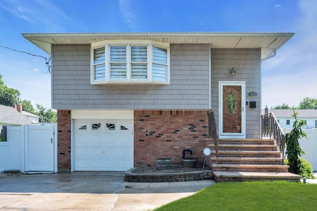 544 S 15th St, Lindenhurst, NY 11757 - view of front of property featuring a garage, concrete driveway, and brick siding