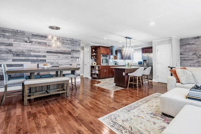 544 S 15th St, Lindenhurst, NY 11757 - living area with wood finished floors, a chandelier, recessed lighting, wooden walls, and an accent wall