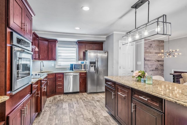 544 S 15th St, Lindenhurst, NY 11757 - kitchen with stainless steel appliances, light wood finished floors, a chandelier, light stone counters, and crown molding