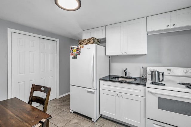 544 S 15th St, Lindenhurst, NY 11757 - kitchen featuring white appliances, white cabinetry, light tile patterned floors, and dark stone counters