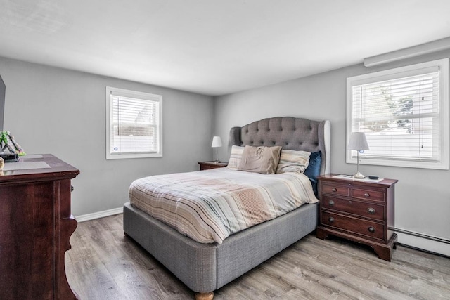 544 S 15th St, Lindenhurst, NY 11757 - bedroom with light wood-style floors, multiple windows, and baseboard heating