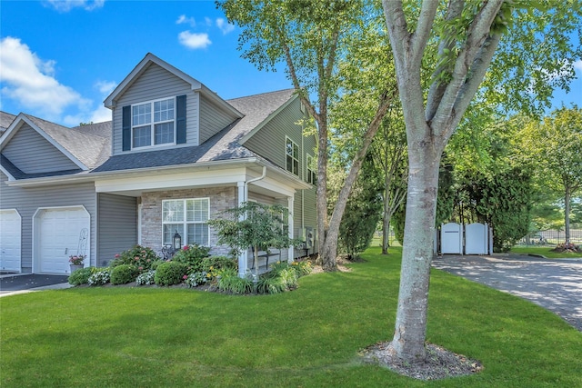 122 Maya Cir, Central Islip, NY 11722 - view of front of house with a front yard, stone siding, an attached garage, a shingled roof, and driveway