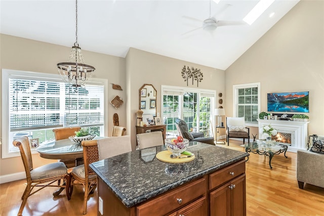 122 Maya Cir, Central Islip, NY 11722 - kitchen with open floor plan, light wood-style flooring, a chandelier, high vaulted ceiling, and a lit fireplace