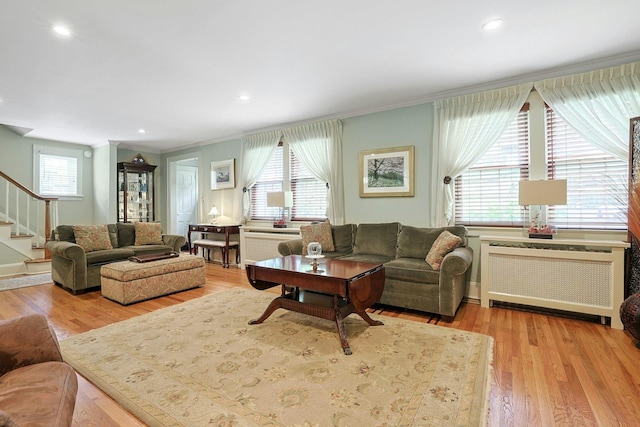 41 Cowdrey St, Yonkers, NY 10701 - living room with radiator heating unit, stairway, ornamental molding, healthy amount of natural light, and wood finished floors