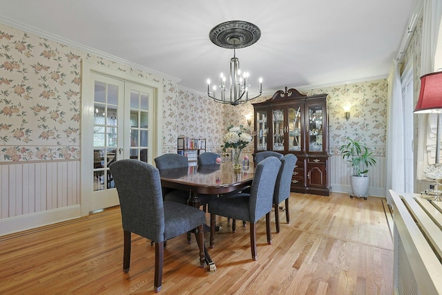 41 Cowdrey St, Yonkers, NY 10701 - dining area featuring wallpapered walls, a chandelier, light wood finished floors, french doors, and crown molding