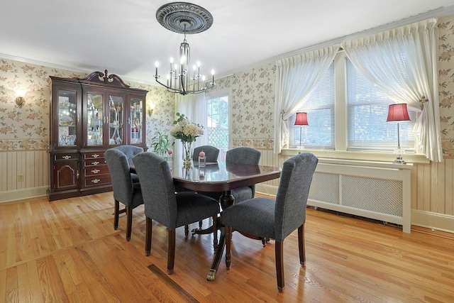 41 Cowdrey St, Yonkers, NY 10701 - dining room with radiator heating unit, wallpapered walls, a chandelier, light wood-style flooring, and a wainscoted wall