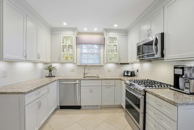 41 Cowdrey St, Yonkers, NY 10701 - kitchen with appliances with stainless steel finishes, white cabinets, decorative backsplash, light tile patterned floors, and light stone countertops