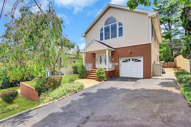 17 Singworth St, Oyster Bay, NY 11771 - view of front of house featuring brick siding, a garage, and driveway