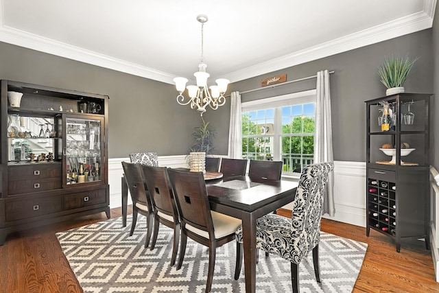 4 Brianna Ln, Yorktown Heights, NY 10598 - dining space with a chandelier, crown molding, a wainscoted wall, wood finished floors, and a decorative wall