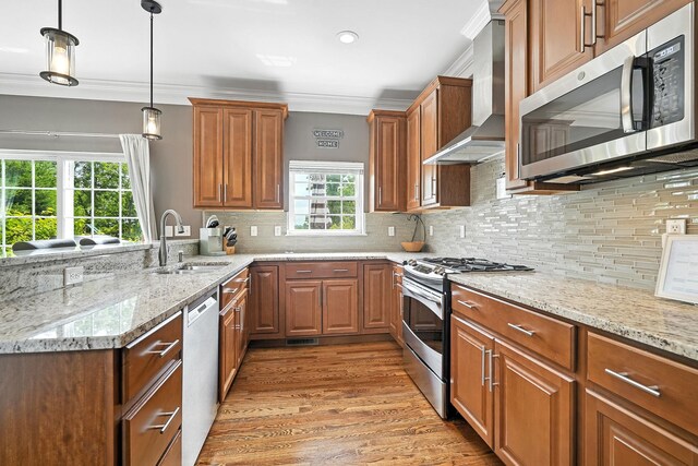 4 Brianna Ln, Yorktown Heights, NY 10598 - kitchen with appliances with stainless steel finishes, wall chimney range hood, light wood finished floors, brown cabinets, and light stone countertops