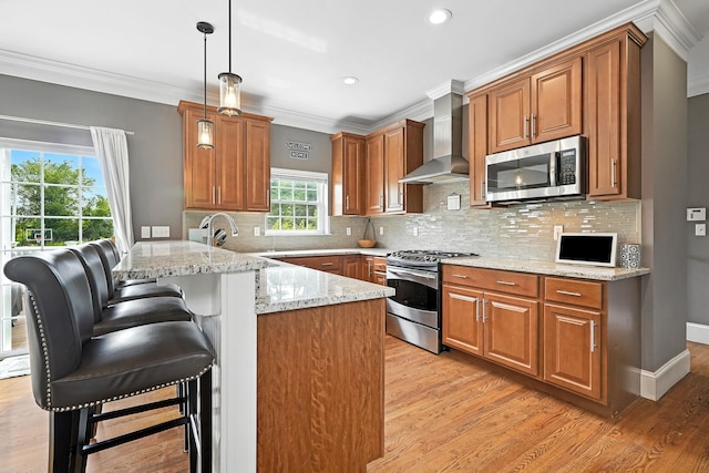 4 Brianna Ln, Yorktown Heights, NY 10598 - kitchen with appliances with stainless steel finishes, wall chimney range hood, a peninsula, ornamental molding, and a kitchen bar