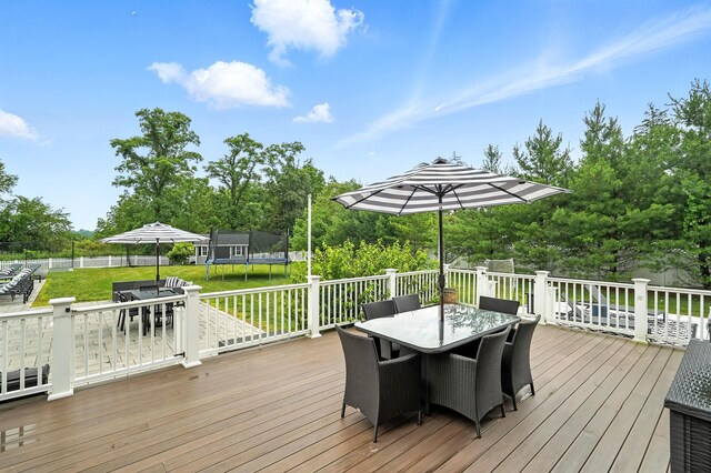 4 Brianna Ln, Yorktown Heights, NY 10598 - wooden deck with outdoor dining area, a trampoline, a yard, and view of scattered trees