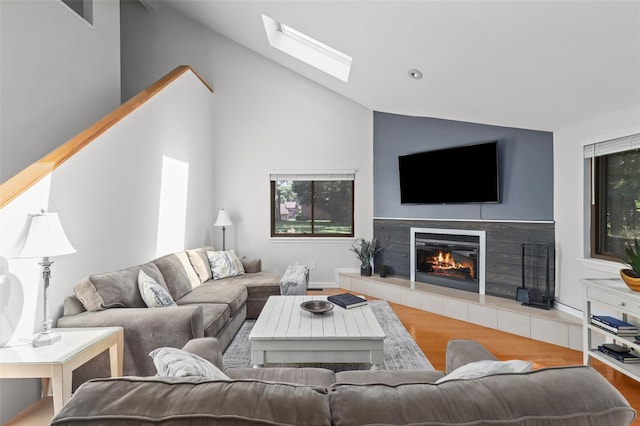 24 Wild Birch Farms, Cortlandt Manor, NY 10567 - living room featuring wood finished floors, vaulted ceiling, a tiled fireplace, and a skylight