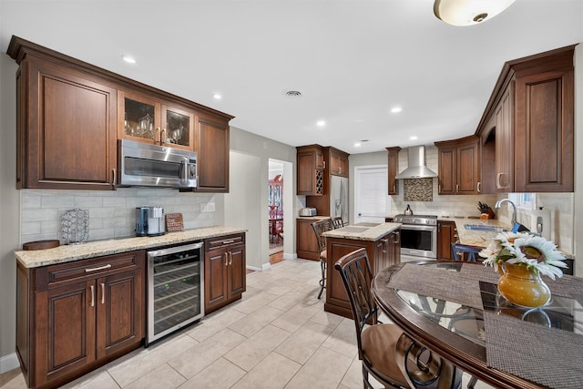 70 Walter Dr, Stony Point, NY 10980 - kitchen featuring beverage cooler, appliances with stainless steel finishes, wall chimney range hood, tasteful backsplash, and recessed lighting