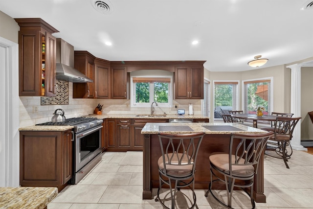 70 Walter Dr, Stony Point, NY 10980 - kitchen featuring gas range, wall chimney exhaust hood, tasteful backsplash, a breakfast bar area, and a center island