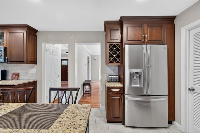 70 Walter Dr, Stony Point, NY 10980 - kitchen with stainless steel fridge with ice dispenser, decorative backsplash, light tile patterned floors, light stone countertops, and dark brown cabinets