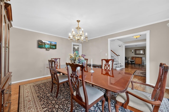70 Walter Dr, Stony Point, NY 10980 - dining space featuring wood finished floors, a chandelier, stairway, and ornamental molding