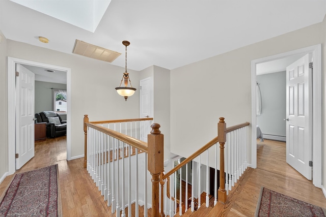 70 Walter Dr, Stony Point, NY 10980 - hallway featuring an upstairs landing, wood finished floors, a skylight, and a baseboard radiator