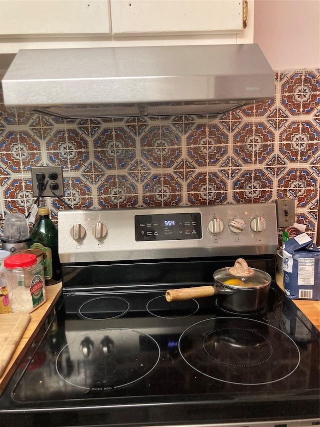 46 Violet Rd, Rocky Point, NY 11778 - kitchen view of electric stove, range hood, and tasteful backsplash
