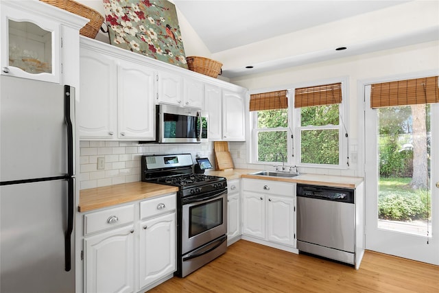 315 Old Salt Rd, Mattituck, NY 11952 - kitchen featuring stainless steel appliances, light countertops, white cabinets, and vaulted ceiling