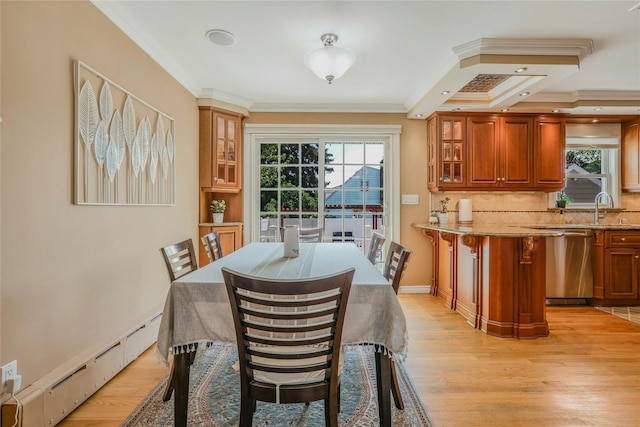 502 S 11th St, New Hyde Park, NY 11040 - dining room featuring baseboard heating, light wood-style floors, and crown molding