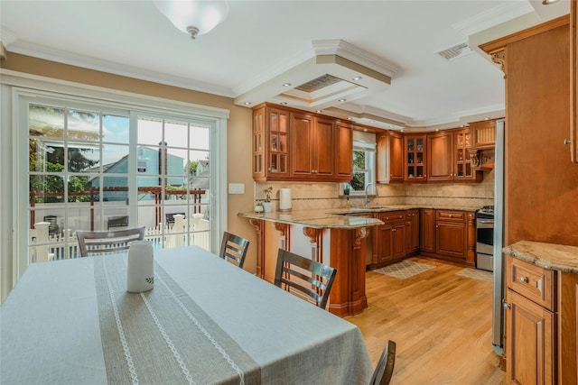 502 S 11th St, New Hyde Park, NY 11040 - kitchen featuring brown cabinetry, electric range, a peninsula, light wood finished floors, and ornamental molding