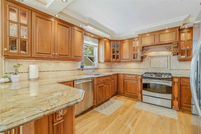 502 S 11th St, New Hyde Park, NY 11040 - kitchen with stainless steel appliances, brown cabinets, crown molding, light wood-type flooring, and a peninsula