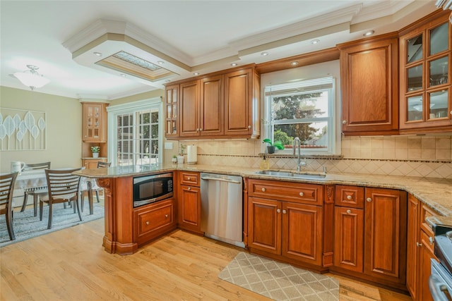 502 S 11th St, New Hyde Park, NY 11040 - kitchen with appliances with stainless steel finishes, a peninsula, brown cabinets, ornamental molding, and light wood-style floors