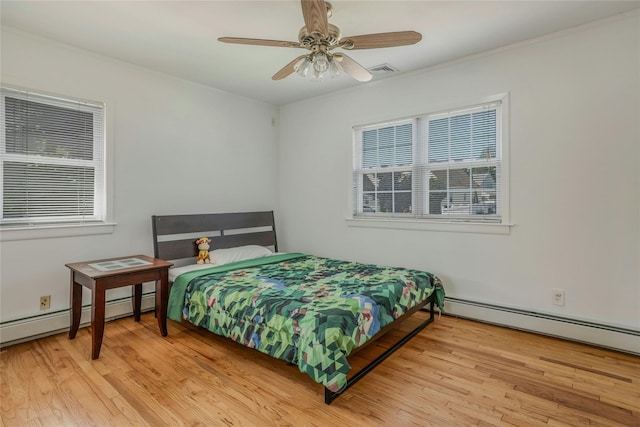 502 S 11th St, New Hyde Park, NY 11040 - bedroom with wood finished floors, baseboard heating, and a ceiling fan