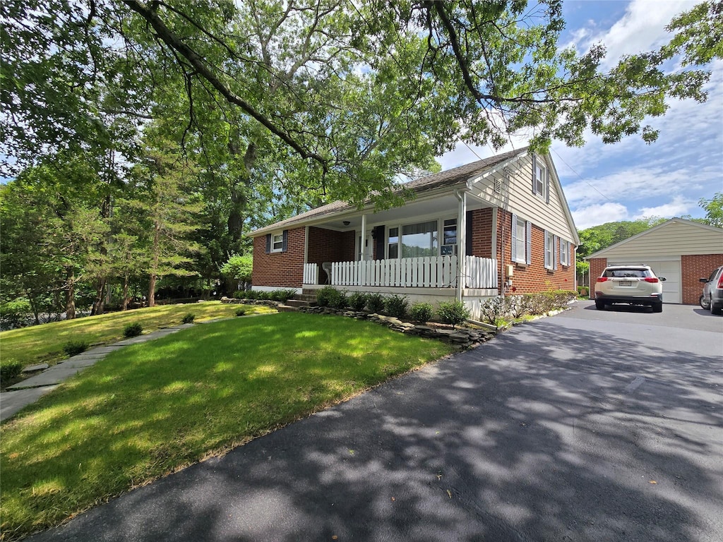 3 Birch St, Airmont, NY 10952 - view of front of house featuring a porch, brick siding, a front lawn, and a garage