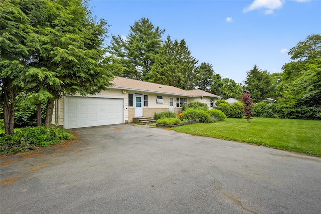 7641 N Broadway, Red Hook, NY 12571 - ranch-style home featuring asphalt driveway, an attached garage, and a front lawn