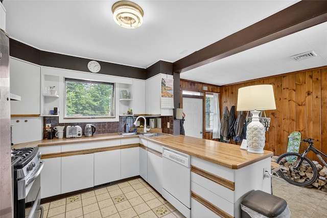 7641 N Broadway, Red Hook, NY 12571 - kitchen featuring white dishwasher, stainless steel range with gas stovetop, open shelves, wood walls, and white cabinets