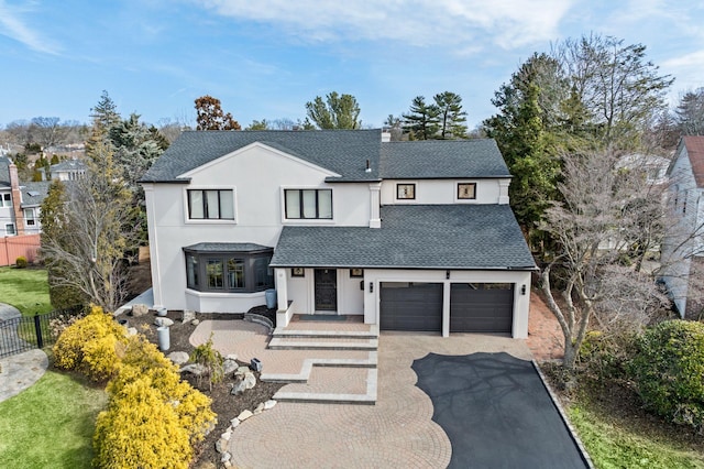 12 Foxhurst Ct, Manhasset Hills, NY 11040 - view of front of property with a shingled roof, stucco siding, driveway, and an attached garage