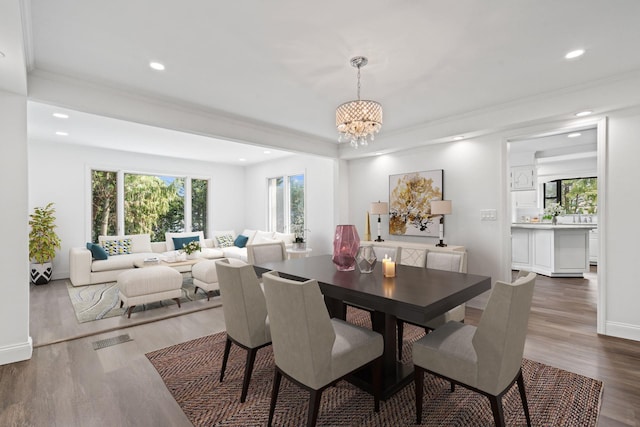 12 Foxhurst Ct, Manhasset Hills, NY 11040 - dining room featuring a chandelier, dark wood-style flooring, recessed lighting, and crown molding
