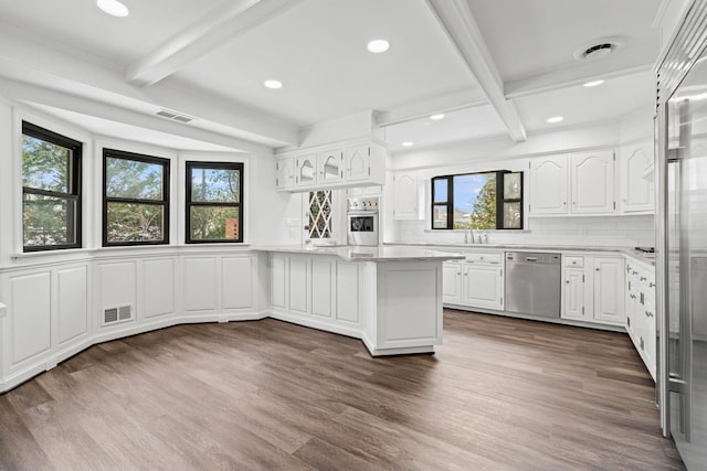 12 Foxhurst Ct, Manhasset Hills, NY 11040 - kitchen with appliances with stainless steel finishes, beam ceiling, dark wood-style floors, healthy amount of natural light, and a peninsula