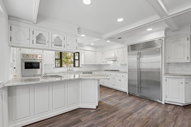 12 Foxhurst Ct, Manhasset Hills, NY 11040 - kitchen with appliances with stainless steel finishes, backsplash, light stone counters, white cabinets, and dark wood-style floors
